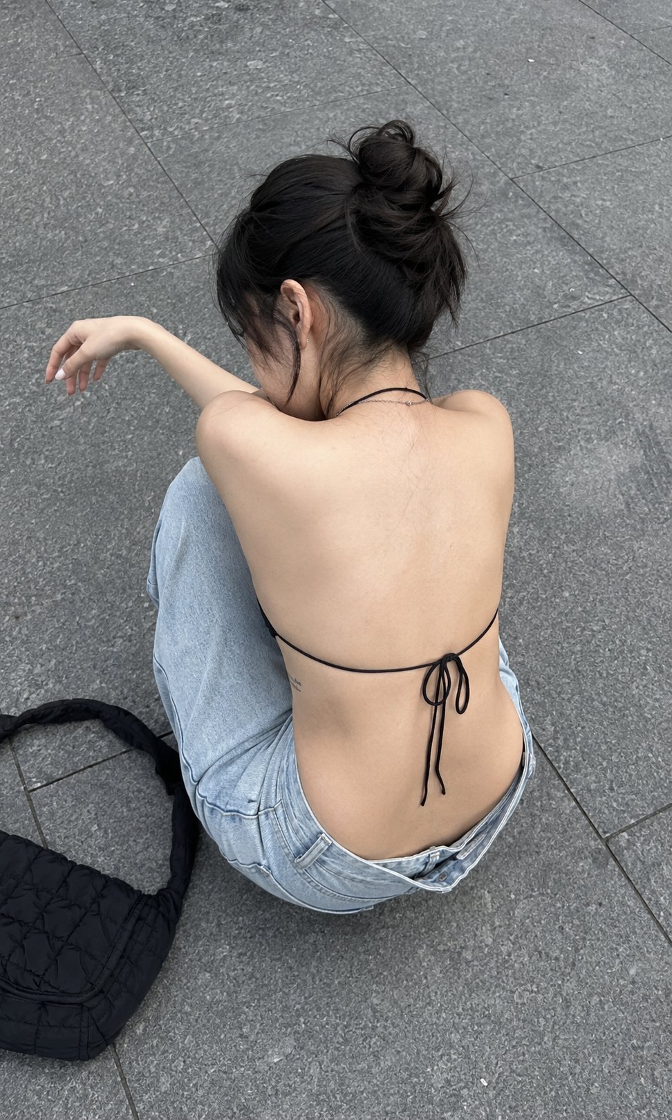 Nanobanana Pro 生成 街头石板路坐姿女性背影手机抓拍 - AI绘画提示词
